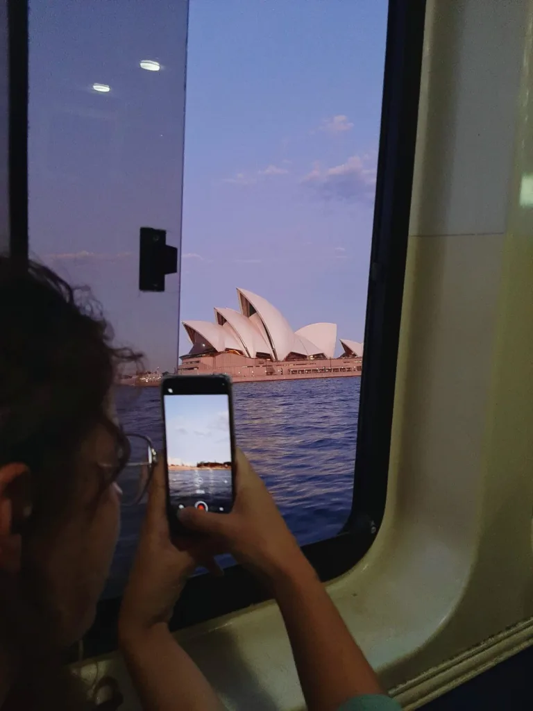 Ferry dans la baie de Sydney avec vue sur l'opréra de Sydney au coucher du soleil